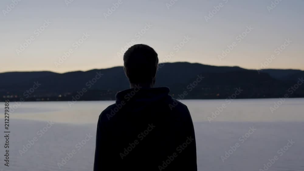 Man Walks Into Frame And Stops Overlooking Lake and Mountains Man Walks Into Frame And Stops Overlooking Lake and Mountains