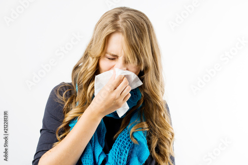 Young pregnant woman wearing blue scarf having flu and using handkerchief, white background .