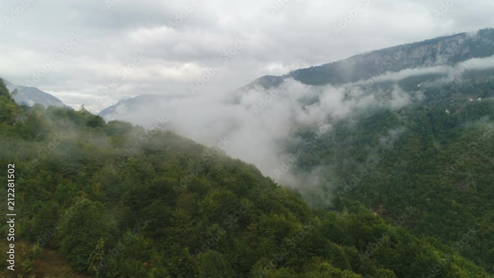 Flying through morning fog in beautiful mountain valley in Montenegro, Southeastern Europe Flying through morning fog in beautiful mountain valley in Montenegro, Southeastern Europe