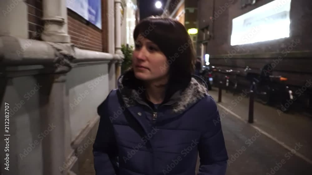 Caucasian woman walks on street evening. Young female traveler. Caucasian woman walks on street evening. Young female traveler.