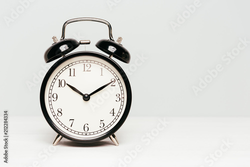 A black clock isolated on light color background.