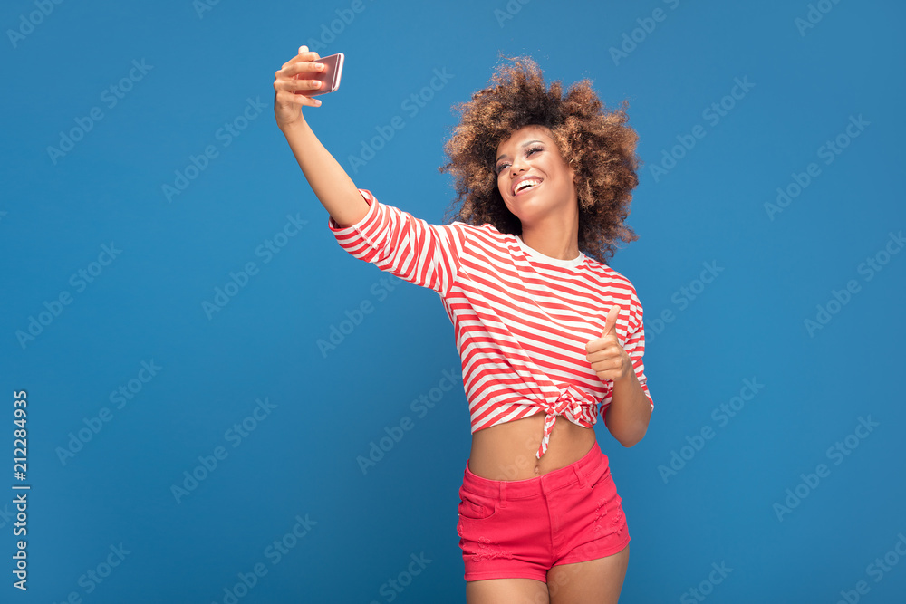 Beautiful african woman holding mobile phone and smiling. Beautiful african woman holding mobile phone and smiling.