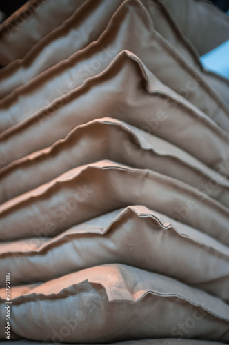 Beige pillows stacked on top of each other closeup with shallow focus photo