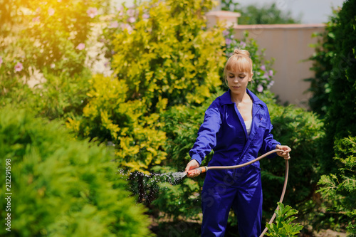 Gardener girl is watering the garden