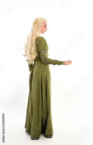 full length portrait of a blonde girl wearing green medieval gown, stand pose, isolated on white studio background. © faestock