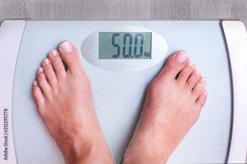 Woman on weighing. Perfect weight for a woman. Weight shows that a woman weighs 50 kg. Weight control_