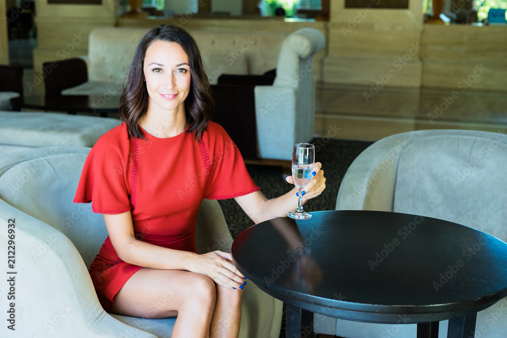 A girl is sitting in a hotel with a glass of water