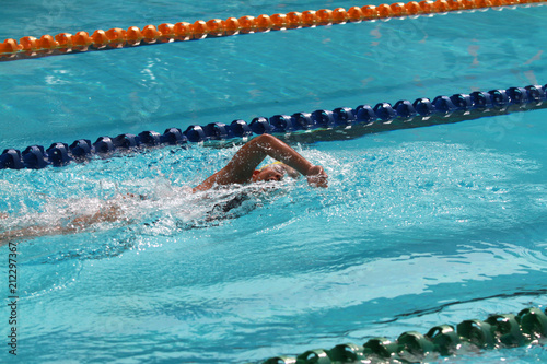 Swimmer swims free style in a swimming pool for competition or race