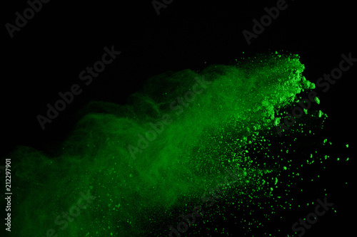 Freeze motion of green powder explosions isolated on black background. Green dust explosive on dark background. Colored clouds splash.