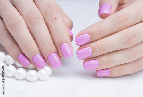 Attractive manicure on women's hands. Natural finger nails with stylish nail art.
