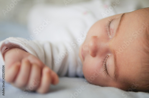 Foto Newborn baby girl sleeping on blue sheets