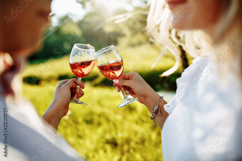 love, dating, people and holidays concept - happy couple drinking champagne on picnic over sunset background