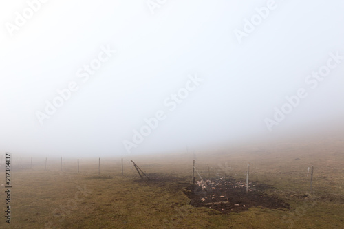 A fence on a mountain in the midst of fog