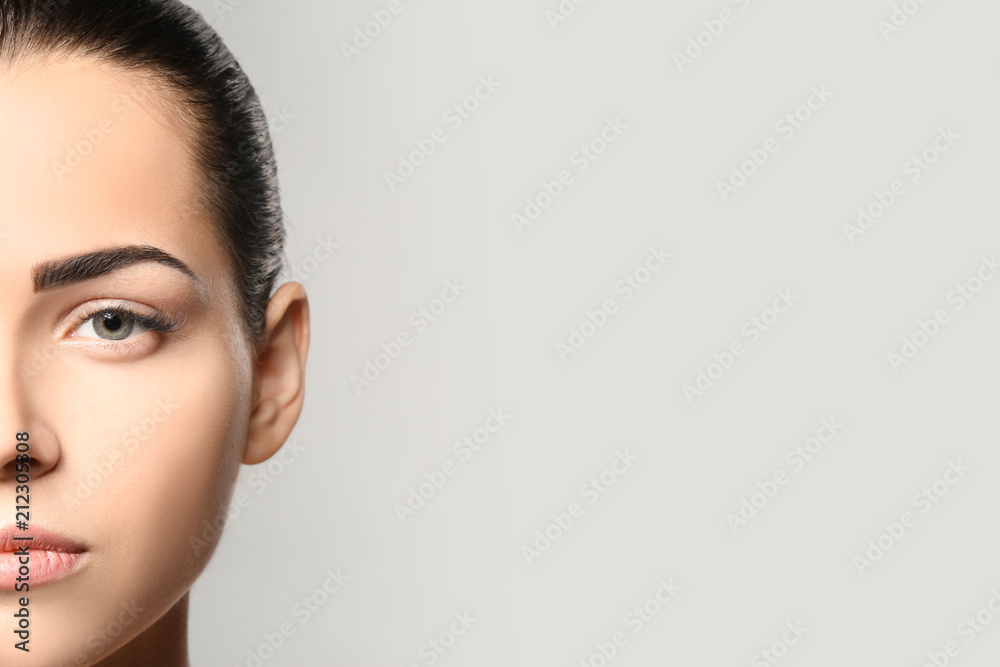 Young woman with permanent eyebrows makeup on grey background - obrazy, fototapety, plakaty 