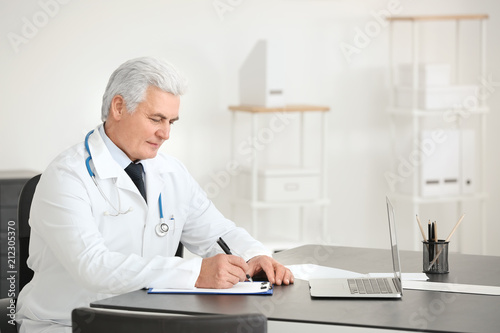 Male doctor filling up appl...