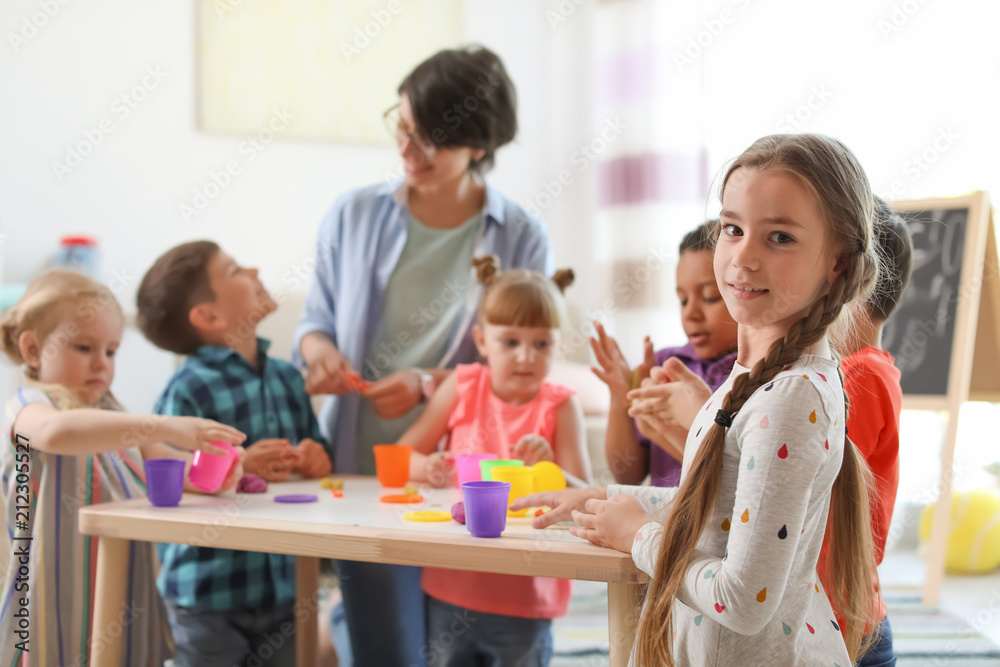 Young woman playing with little children indoors Young woman playing with little children indoors