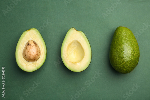 Flat lay composition with ripe avocados on color background