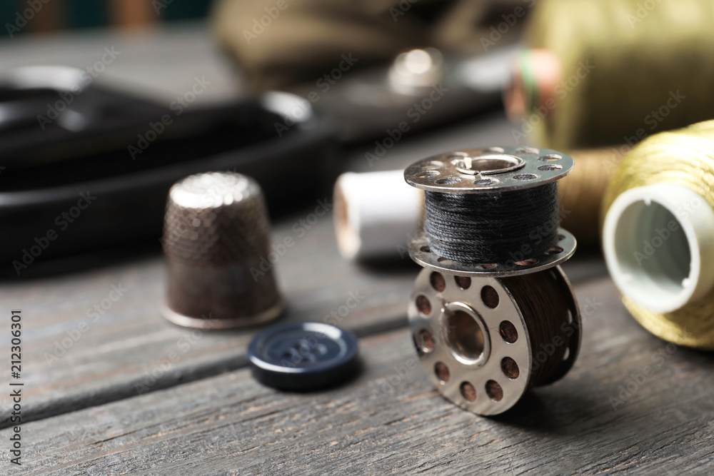 Bobbins with threads on table. Tailoring accessories
