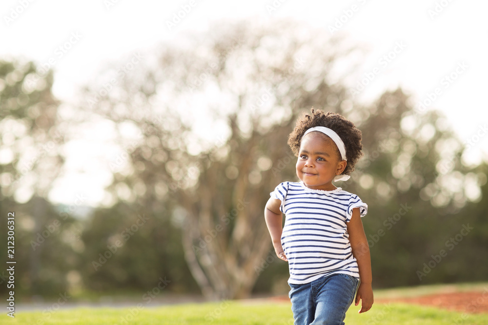 Happy little girl laughing and smiling outside.