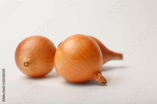 Fresh ripe onion bulbs on light background