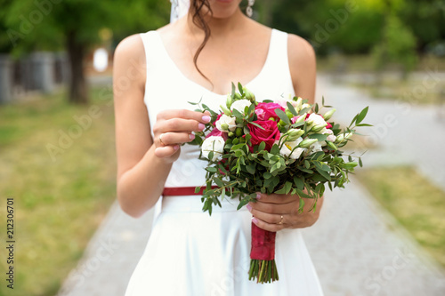 Woman in wedding gown with beautiful bridal bouquet outdoors, closeup © New Africa