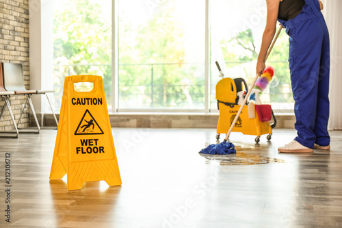 Tablou pe pânză Safety sign with phrase Caution wet floor and cleaner indoors