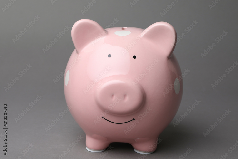 Cute pink piggy bank on gray background Cute pink piggy bank on gray background