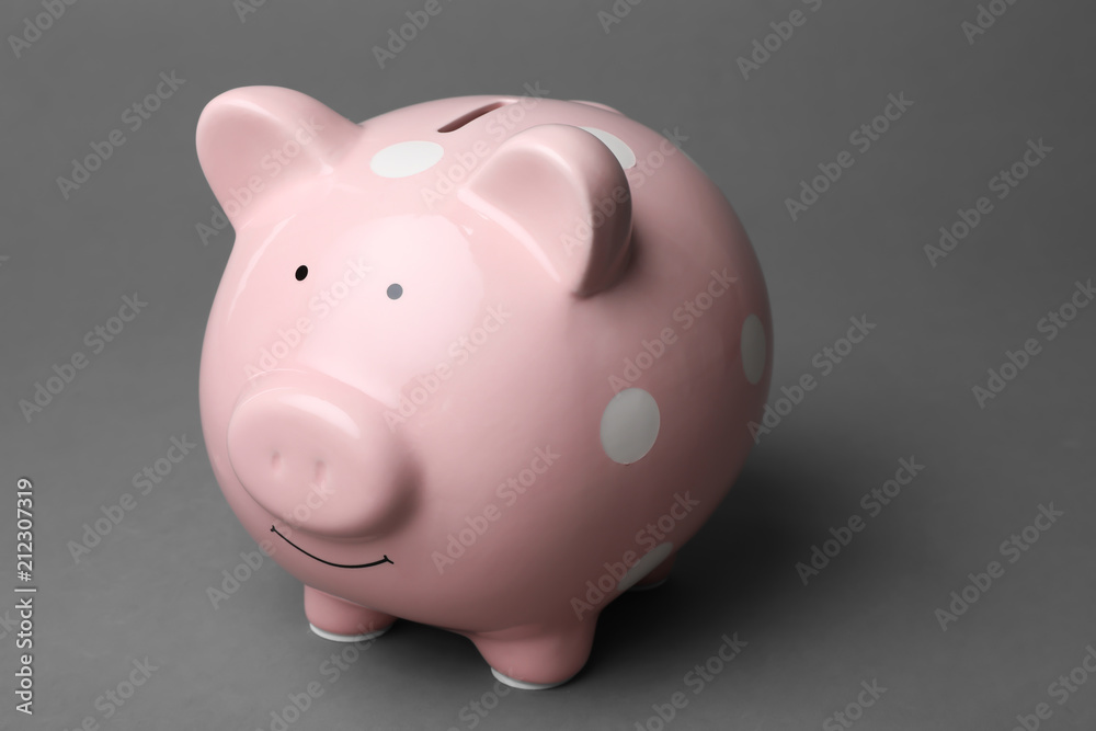 Cute pink piggy bank on gray background
