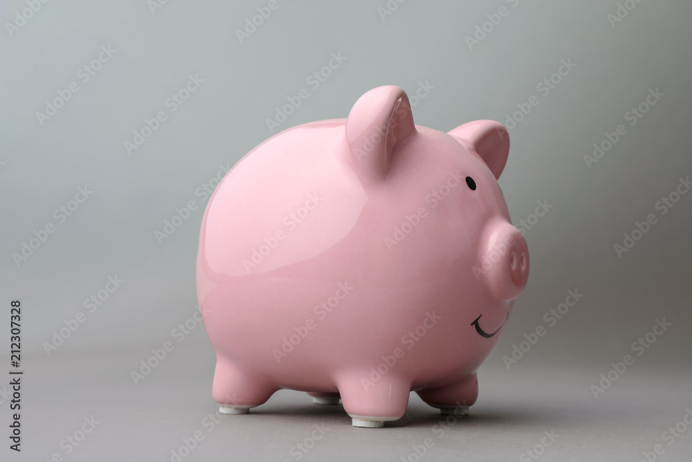 Cute pink piggy bank on gray background Cute pink piggy bank on gray background