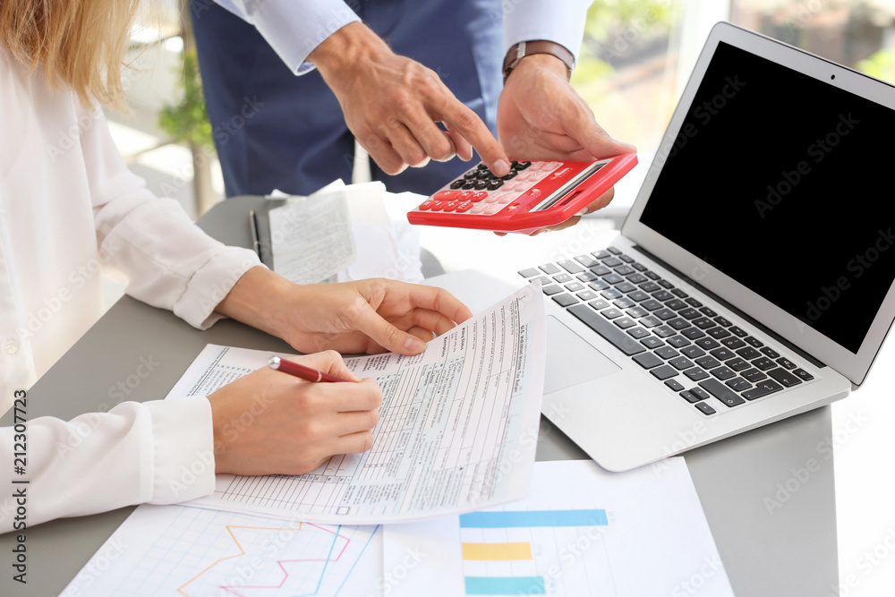Tax accountants working with documents at table Tax accountants working with documents at table