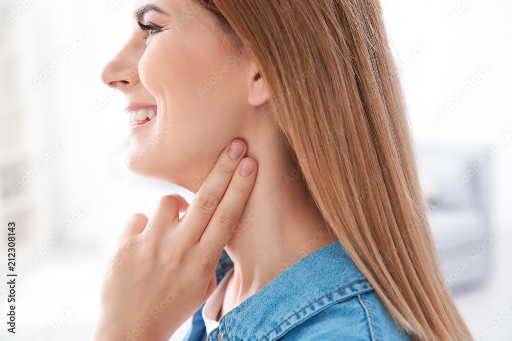 Young woman checking pulse on blurred background