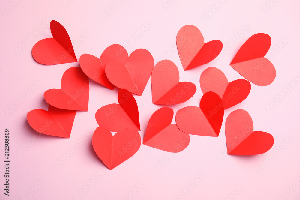 Small paper hearts on color background