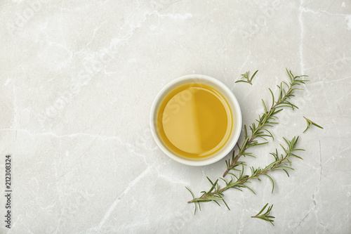 Flat lay composition with rosemary oil on light background