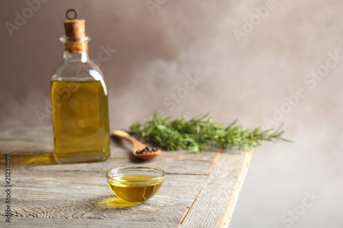 Bowl of rosemary oil on wooden table