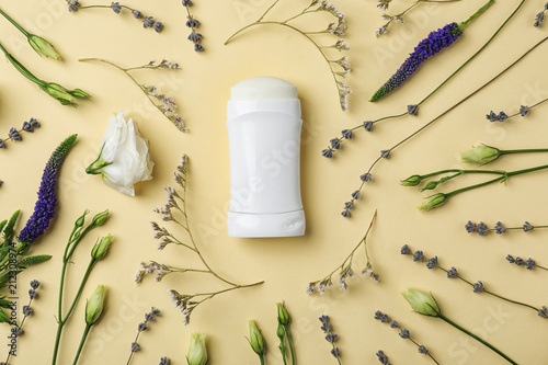 Flat lay composition with deodorant and herbs on color background photo