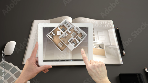 Augmented reality concept. Hand holding tablet with AR application used to simulate 3d pop-up interactive room maps to life