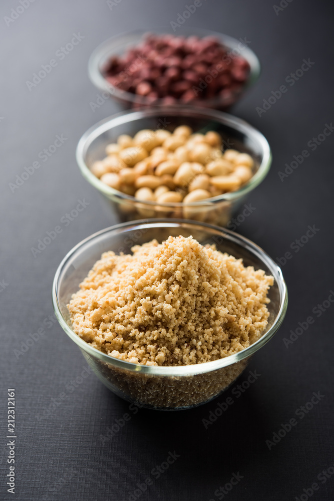 Crushed peanuts or mungfali powder with whole and roasted groundnut. Served in a bowl over moody background. Selective focus Crushed peanuts or mungfali powder with whole and roasted groundnut. Served in a bowl over moody background. Selective focus