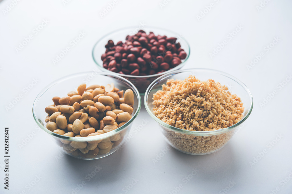 Crushed peanuts or mungfali powder with whole and roasted groundnut. Served in a bowl over moody background. Selective focus Crushed peanuts or mungfali powder with whole and roasted groundnut. Served in a bowl over moody background. Selective focus