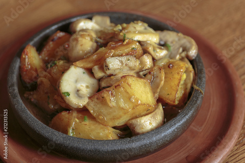Frying pan with potato and mushrooms, stir-fried vegetables, vegan food.