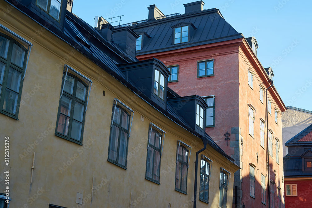  Windows and roofs and walls, shadows and morning rising sun in Old city in Stockholm, Sweden. 