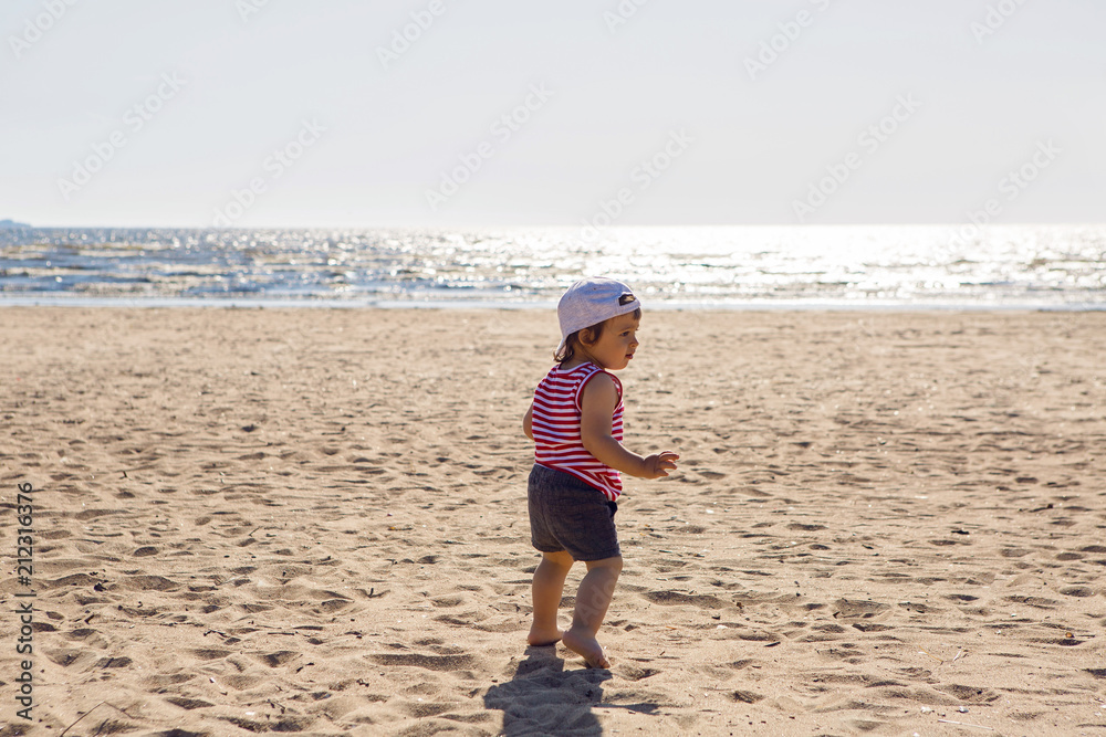 child in a t-shirt and shorts walks