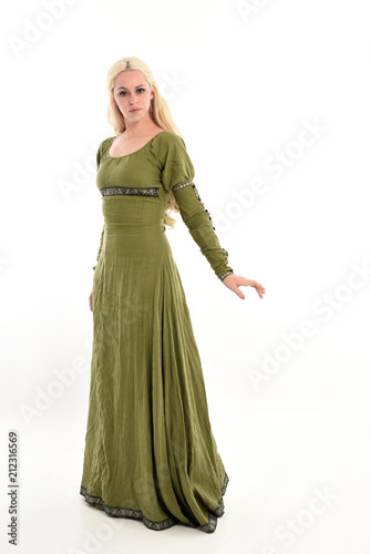 full length portrait of blonde girl wearing long green medieval dress. standing pose, isolated on white studio background.