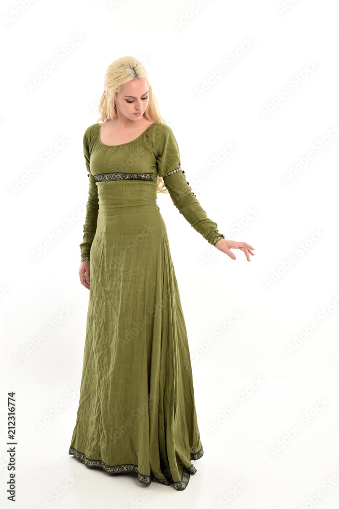 full length portrait of blonde girl wearing long green medieval dress. standing pose, isolated on white studio background. full length portrait of blonde girl wearing long green medieval dress. standing pose, isolated on white studio background.