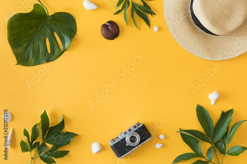 Flat lay design of yellow background with laptop, photo camera, green palm tr...