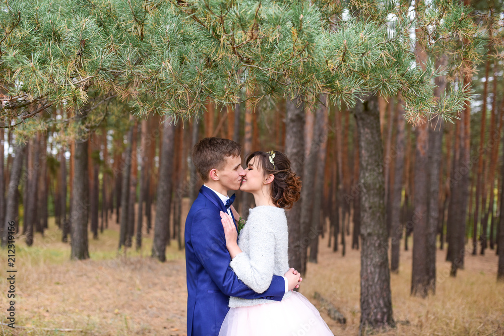 Lovely bride and groom hold each other tender standing in an autumn forest Lovely bride and groom hold each other tender standing in an autumn forest