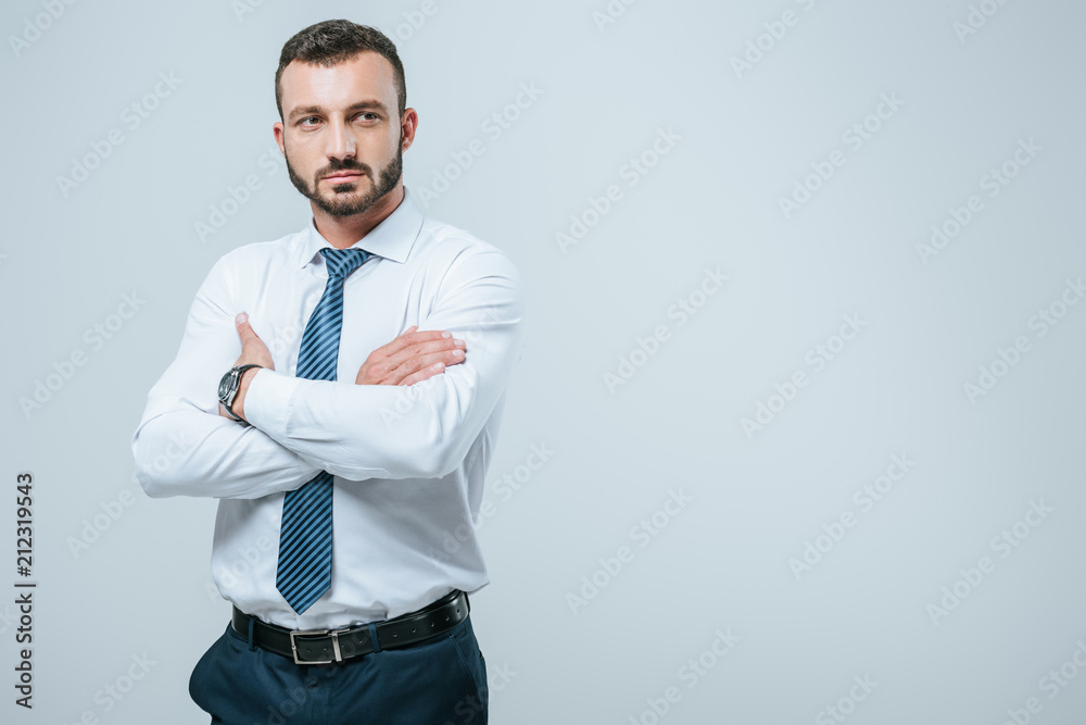 handsome businessman standing with crossed arms isolated on grey handsome businessman standing with crossed arms isolated on grey