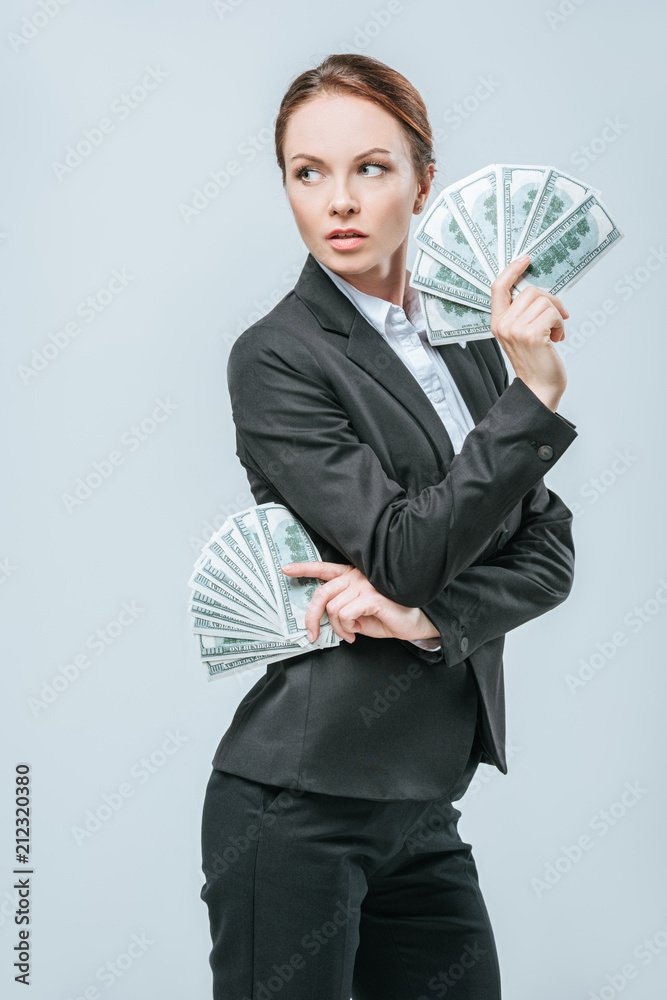 attractive financier posing with dollar banknotes and looking away isolated on grey attractive financier posing with dollar banknotes and looking away isolated on grey