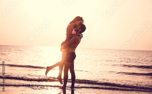 Couple in love having romantic tender moments at sunset on the beach photo