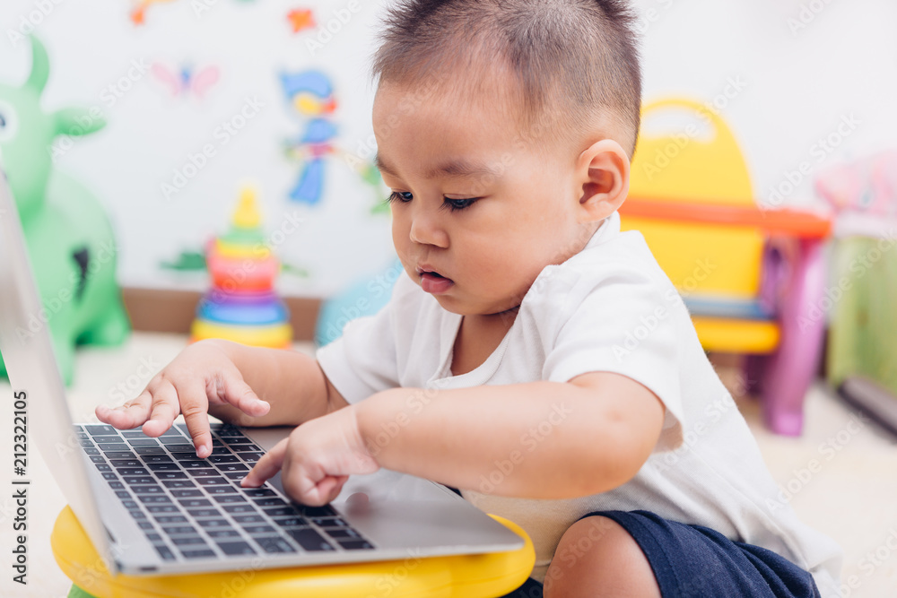 Child baby boy working using laptop computer Child baby boy working using laptop computer