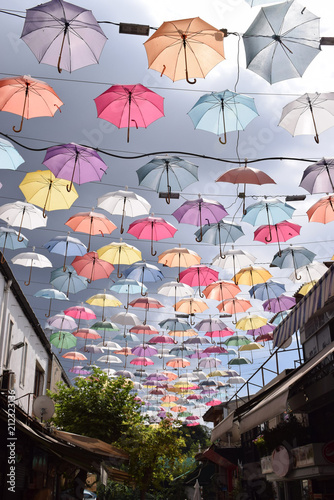 Multicolored umbrellas hang from the top between the streets to protect from the sun. Turkey  Antalya.